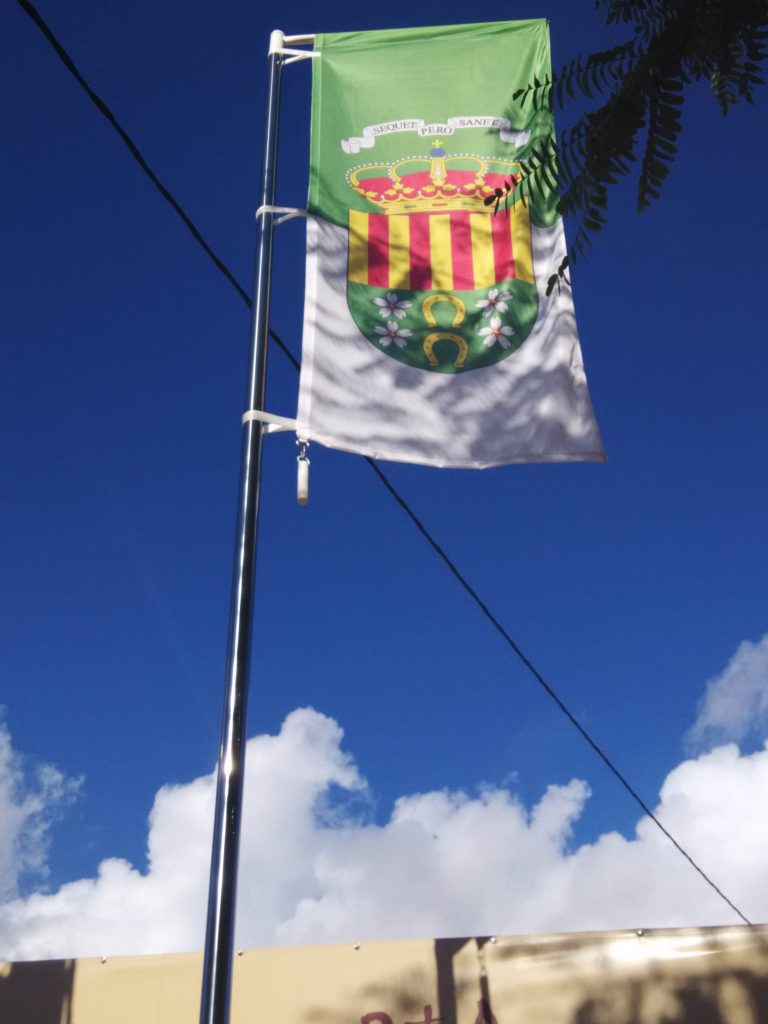 BANDERA LOCAL EXPUESTA EN UN MASTIL DE ACERO INOXIDABLE