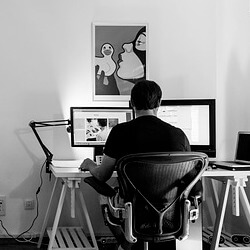 DISEÑADOR DELANTE DE ORDENADOR HACIENDO EL DISEÑO DE UNA BANDERA